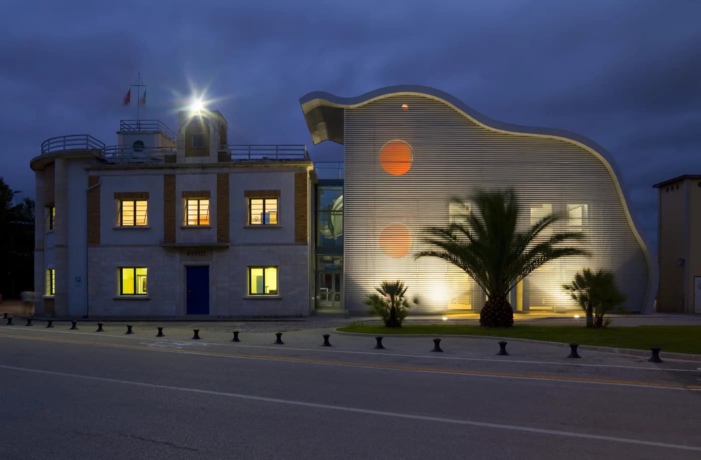 Historic building beside a new extension illuminated at night