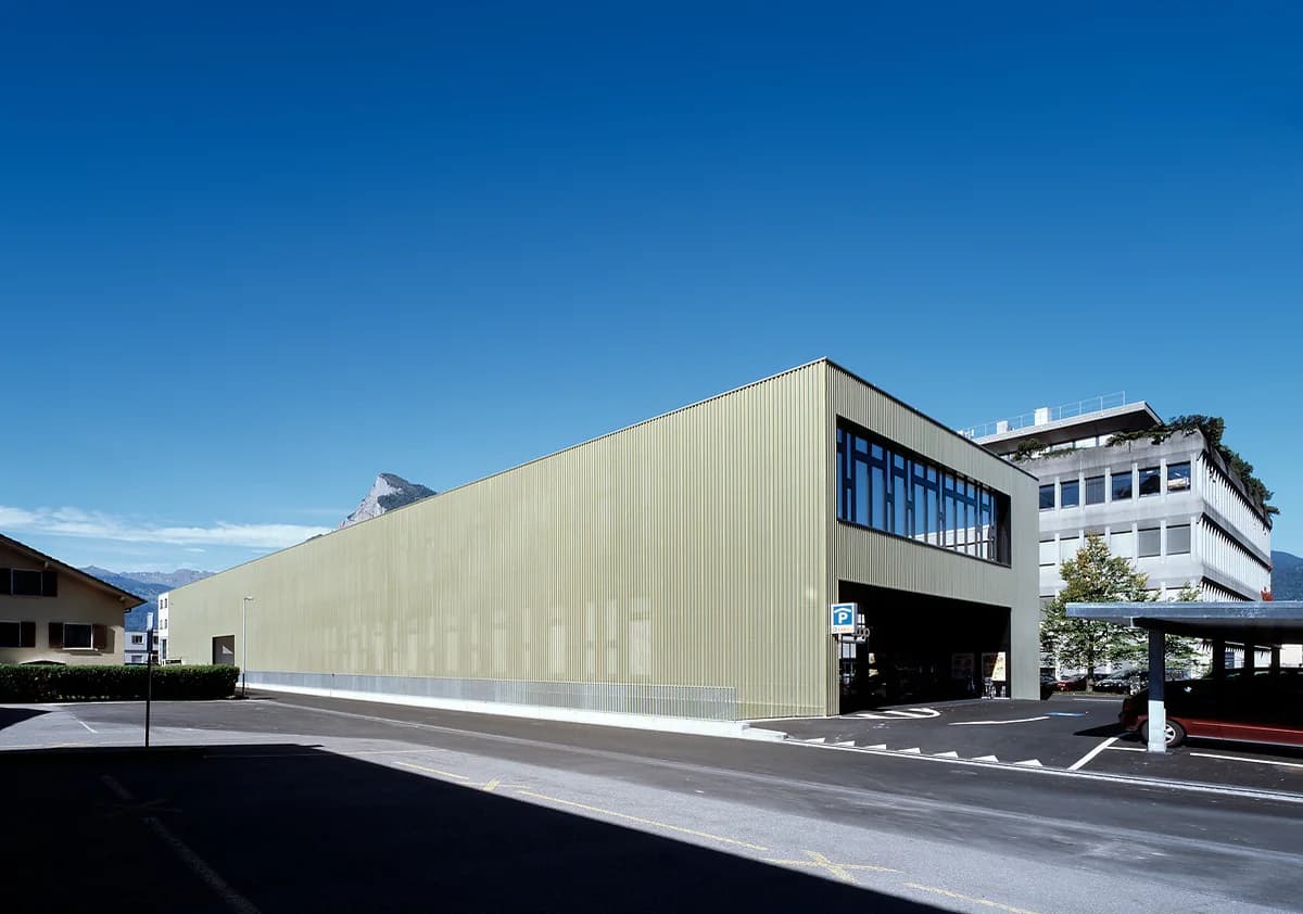 Gold-clad industrial building against a mountain backdrop