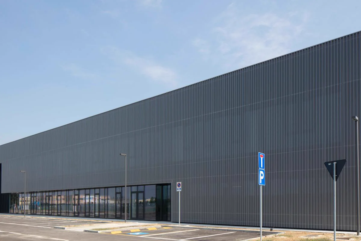 Long industrial building with grey cladding and glazed frontage