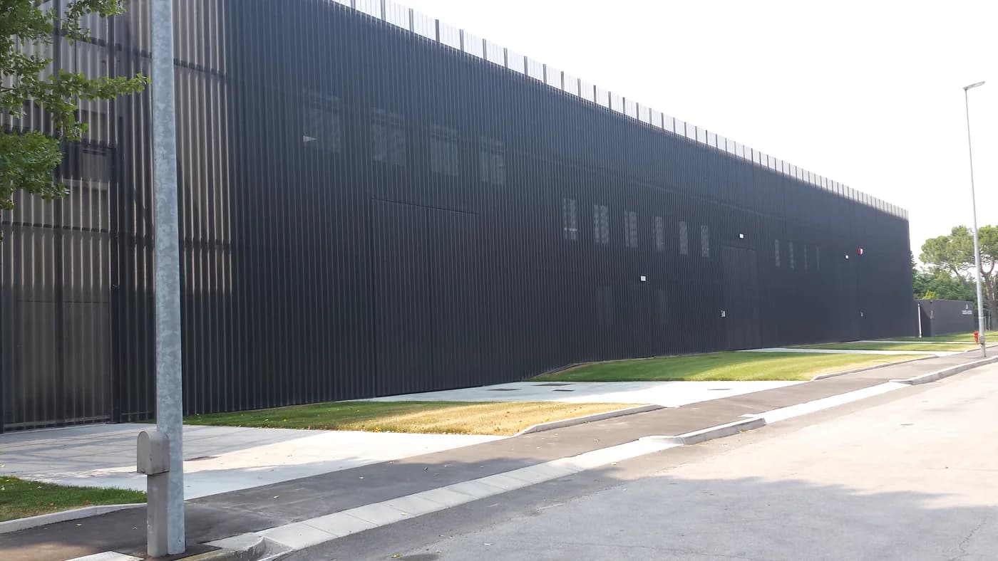 Long dark metal façade beside a road