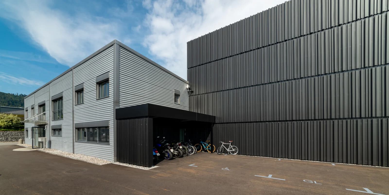 Grey office building beside a black production building